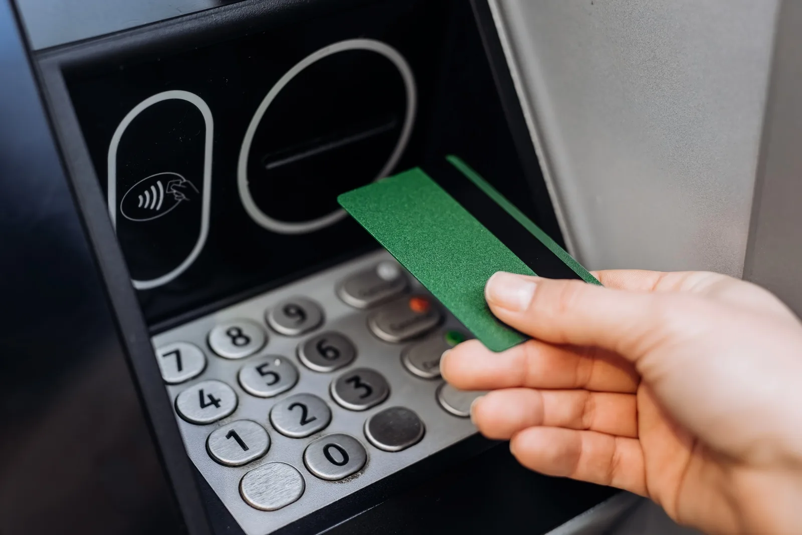 Close up of a credit union debit card being inserted into an ATM card reader